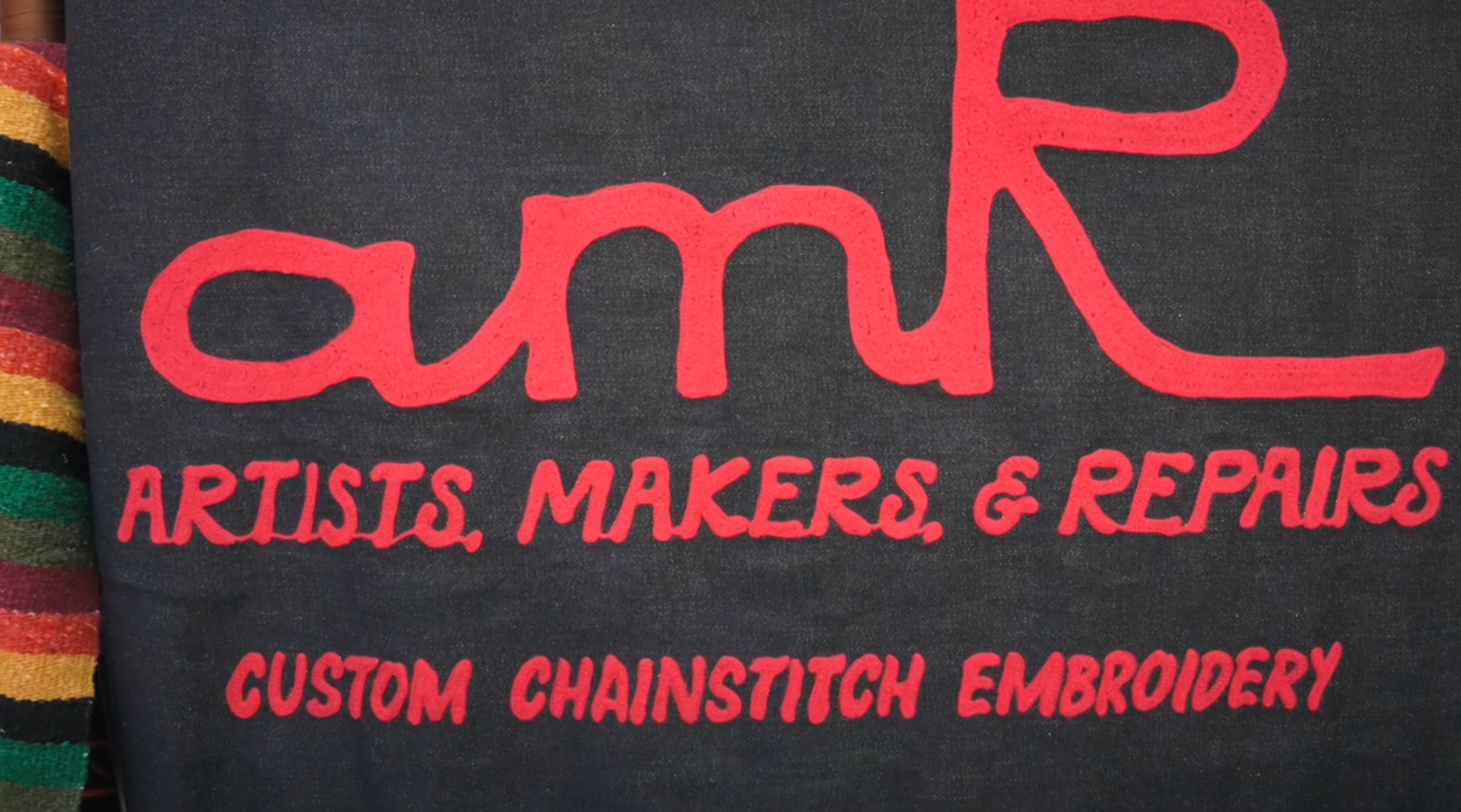 amR artist creating live chainstitch embroidery for guests at an event