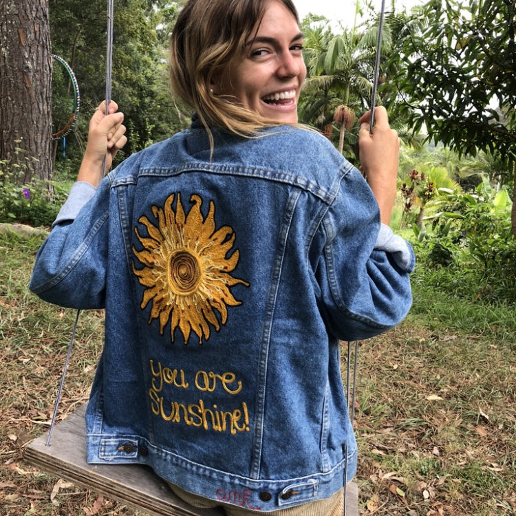 Bespoke denim jacket with hand-guided chainstitch sun artwork and custom back lettering