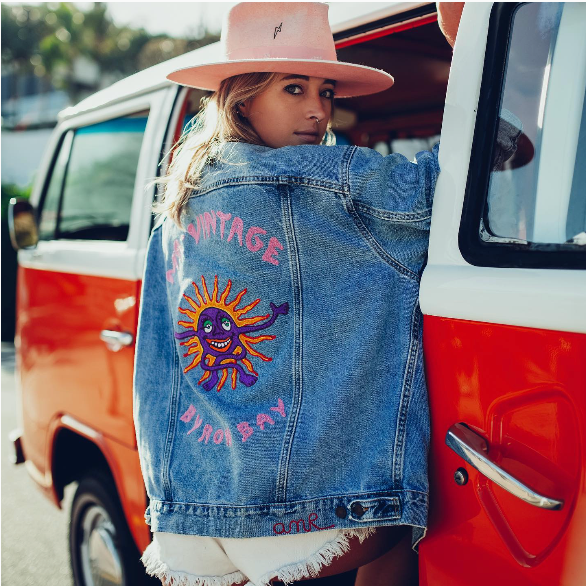 Woman wearing a custom Vintage Byron Bay denim jacket with chainstitch embroidery by amR