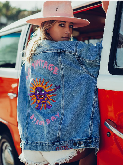 Woman wearing a custom Vintage Byron Bay denim jacket with chainstitch embroidery by amR