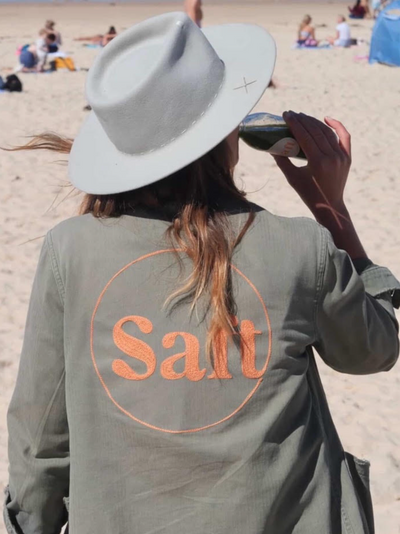Custom chainstitch embroidered jacket with Salt lettering, worn on the beach in Sydney