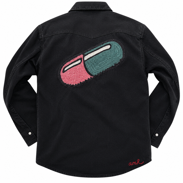 Custom chainstitch embroidery on a black denim western shirt, featuring a large pink and teal pill-shaped design with intricate textured stitching, contrasting black outlines and a red amR signature on the back