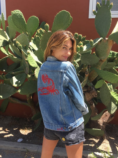 Woman wearing a custom denim jacket with red chainstitch embroidery by amR in Los Angeles