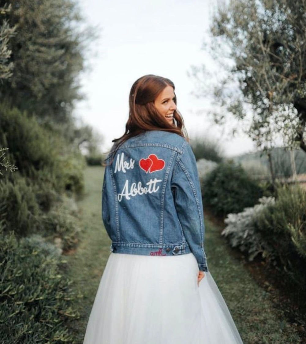 Personalised embroidered denim jacket with couple's names and heart artwork, created as a custom wedding gift