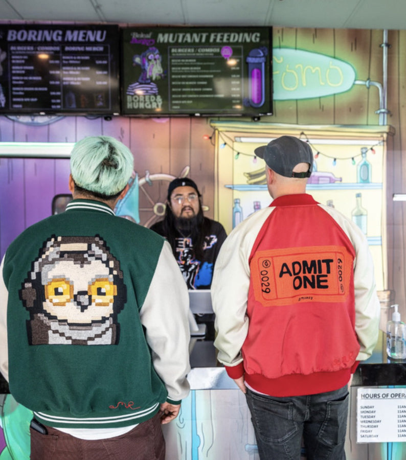 Two custom varsity jackets featuring large custom embroidery and statement back artwork by amR