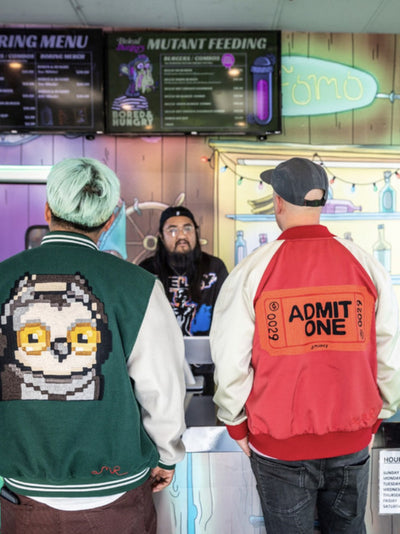 Two custom varsity jackets featuring large custom embroidery and statement back artwork by amR