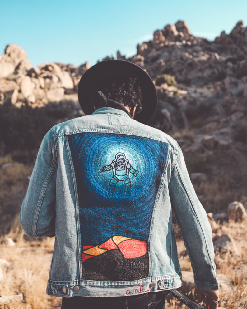 Custom embroidered denim jacket with astronaut artwork photographed in the Southern California desert