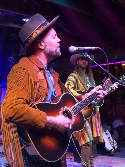 Australian musician performing live in a custom-made Western hat with chainstitch embroidery by amR