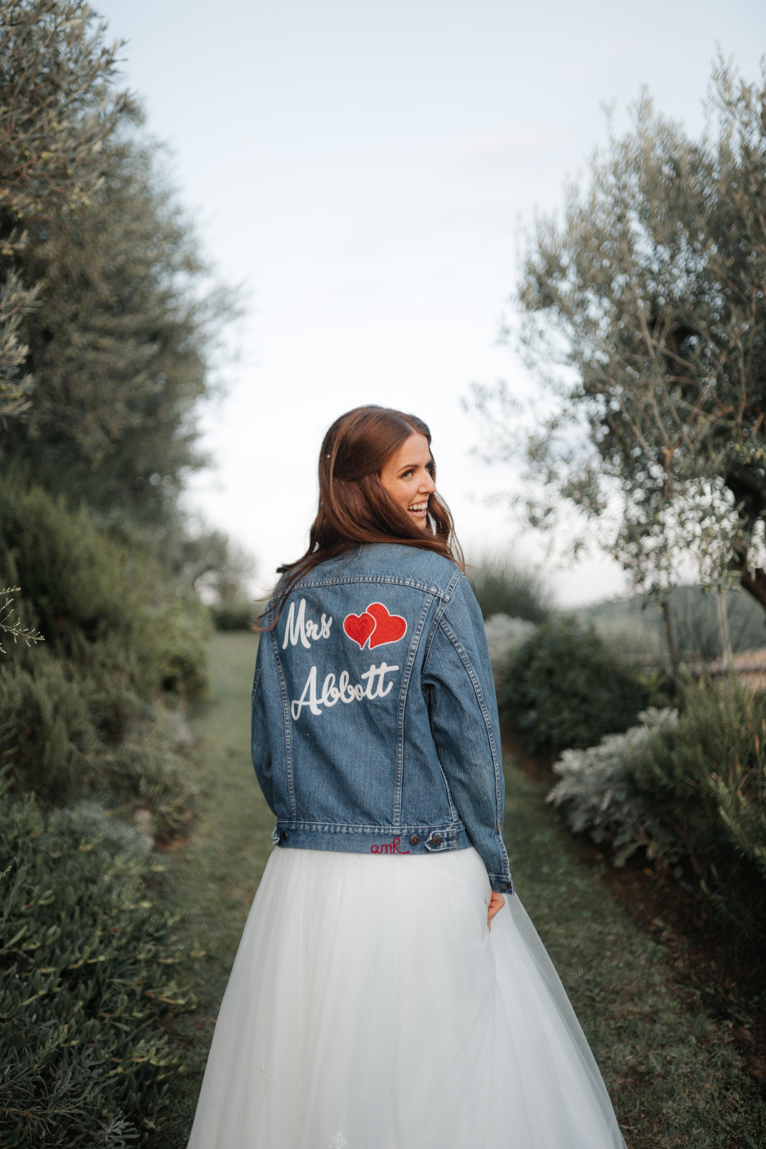 Bride wearing a custom denim jacket with personalised name and heart embroidery by amR for a wedding in London, UK