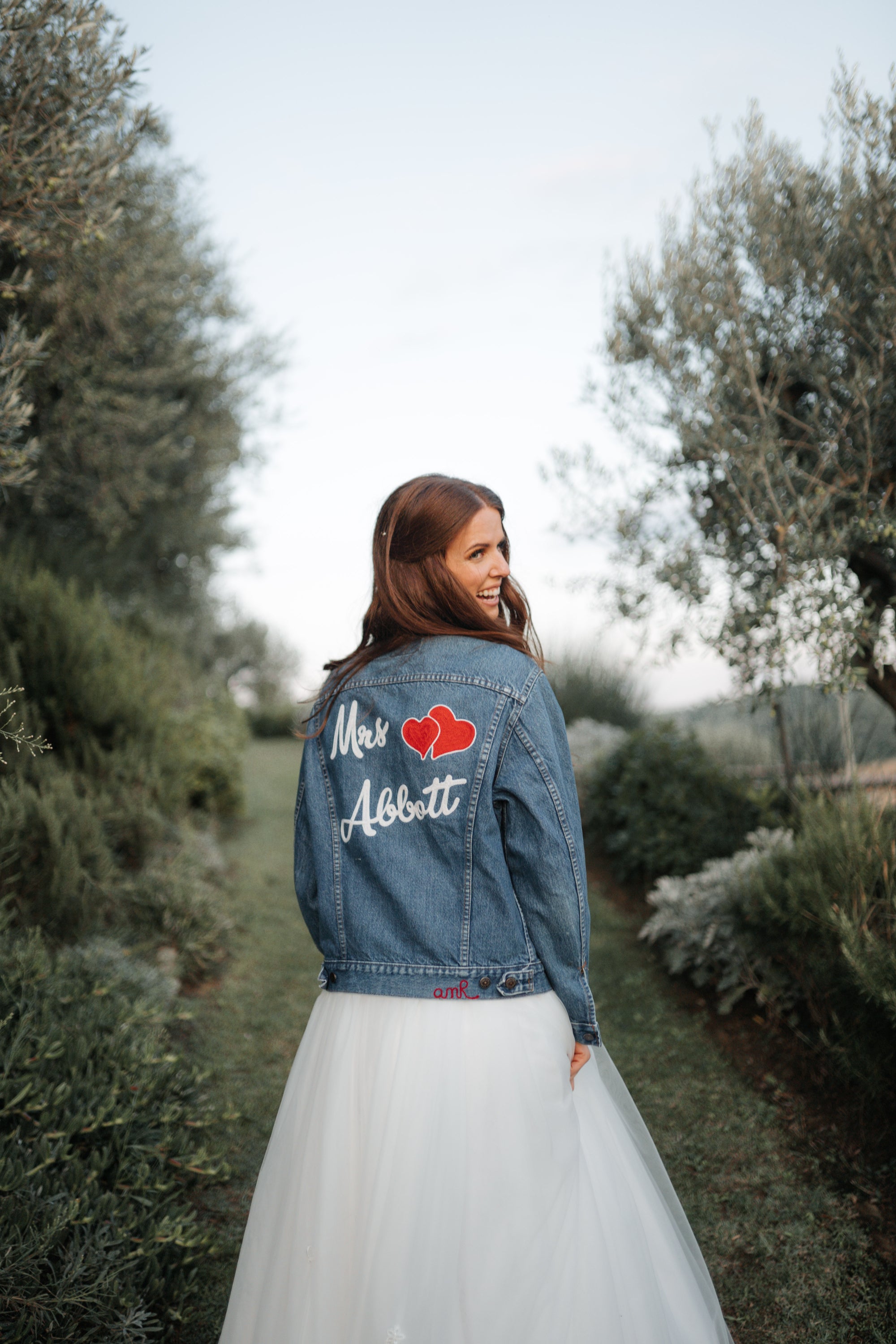 Bride wearing a custom denim jacket with personalised name and heart embroidery by amR for a wedding in London, UK