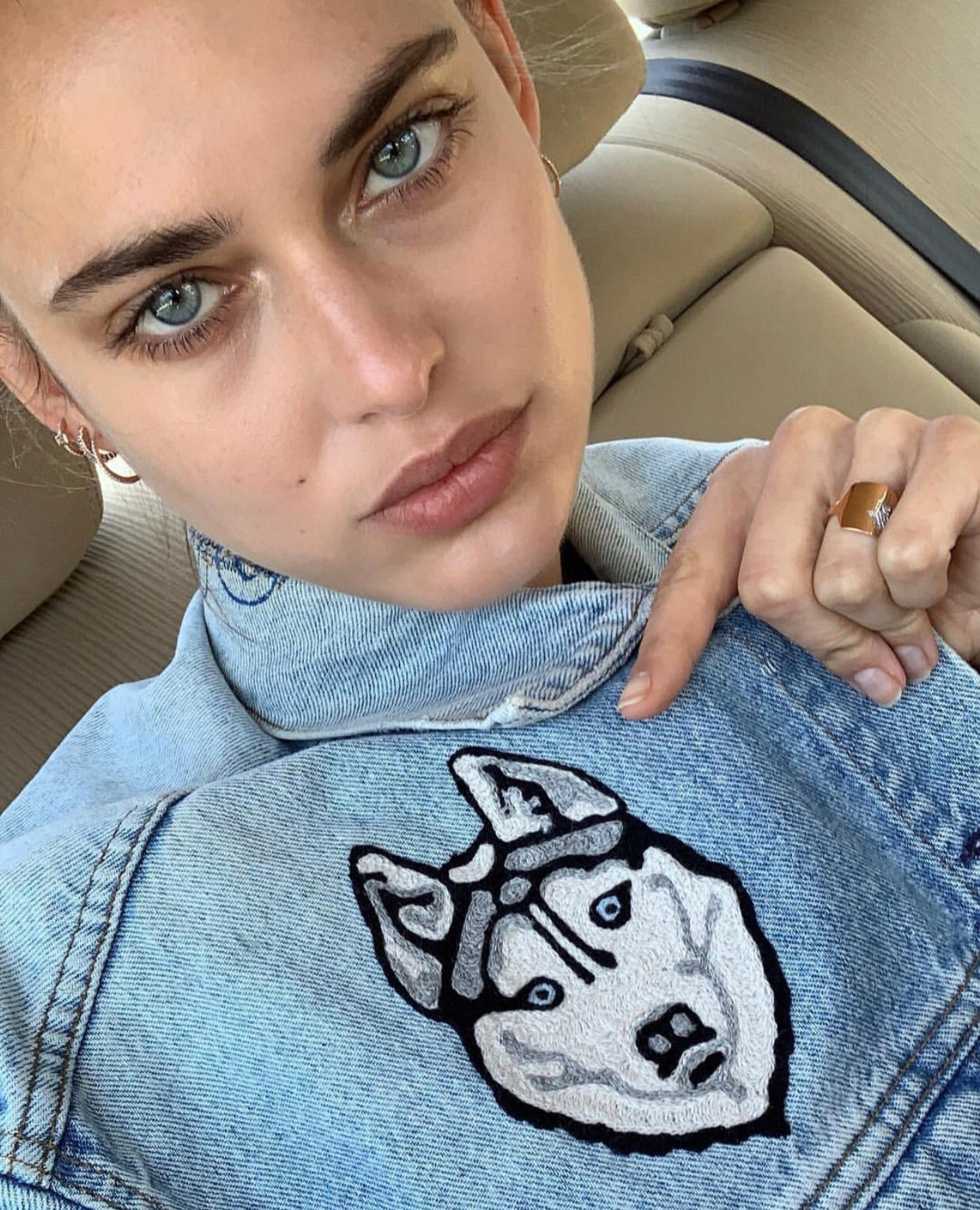 Woman wearing a custom denim jacket with bold embroidered dog artwork by amR in Los Angeles