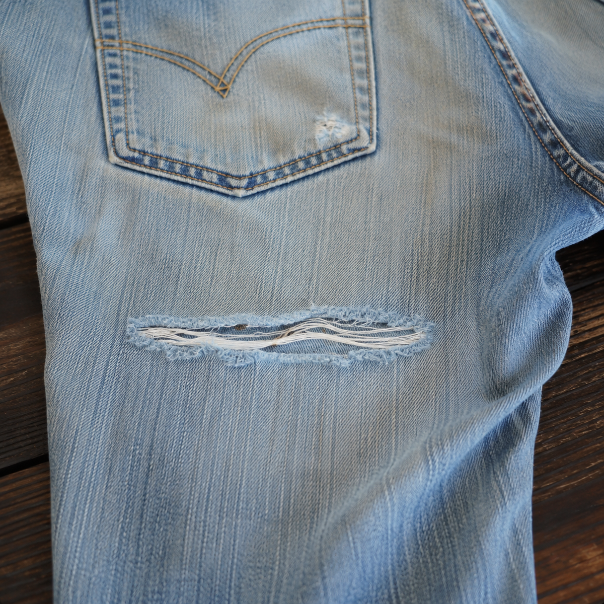 Worn vintage jeans with a torn area before denim repair in Marina del Rey, CA