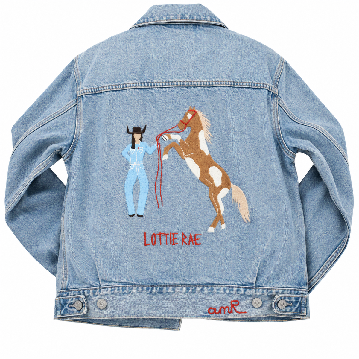 Custom chainstitch embroidery denim jacket created for Lottie Rae x Levi’s, featuring a cowgirl in a light blue western outfit beside a rearing brown and white horse, with LOTTIE RAE stitched in red on the back